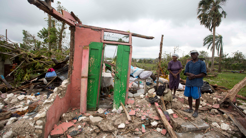 Saintanor Dutervil stands with his wife in the ruins of their home destroyed by Hurricane Matthew in Les Cayes, Haiti, Thursday, Oct. 6, 2016. Two days after the storm rampaged across the country’s remote southwestern peninsula, authorities and aid workers still lack a clear picture of what they fear is the country’s biggest disaster in years. (Image: AP)